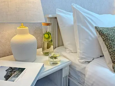 a table with a lamp and a vase on a bed at The Encino - luxury seaside suite in Larnaka