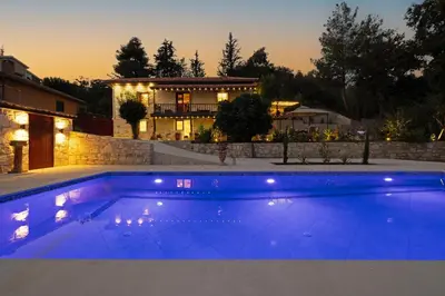 a large blue swimming pool in front of a house at No 1 Mandria in Limassol