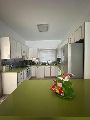 a large kitchen with a green counter top in it at Villa Serenity in Protaras