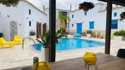 a pool with yellow chairs and a table in front of a house at Little Stone House in Lymbia