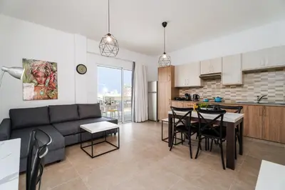 a living room and kitchen with a couch and a table at SunnyVillas 1 Bedroom Central Protaras in Protaras