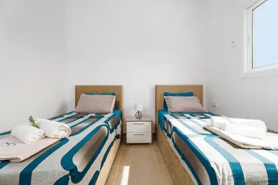 two beds sitting next to each other in a room at SunnyVillas 1 Bedroom Central Protaras in Protaras