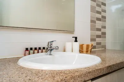 a bathroom counter with a sink and a mirror at SunnyVillas 1 Bedroom Central Protaras in Protaras