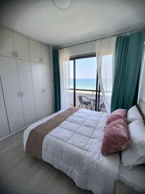 a bedroom with a bed with a view of the ocean at Sunorama Beach Garden - Seaview in Larnaka