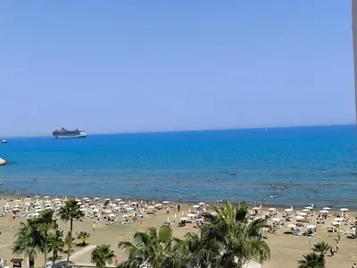 a beach with lots of umbrellas and people in the water at Sunorama Beach Garden - Seaview in Larnaka