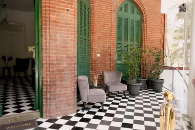 a porch with two chairs and a checkered floor at Semiramis Boutique Hotel & Spa in Kato Platres