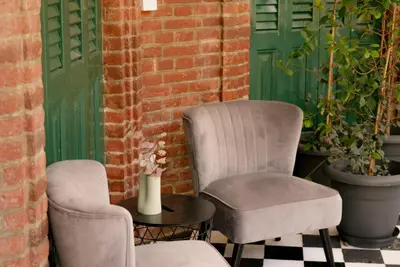two chairs and a table on a patio with a green door at Semiramis Boutique Hotel & Spa in Kato Platres