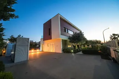 a large white house with a parking lot at Royal Oasis Villa in Ayia Napa