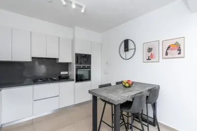 a kitchen with white cabinets and a table with apples on it at Mediterranean Oasis Protaras in Protaras