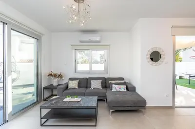 a living room with a couch and a table at Mediterranean Oasis Protaras in Protaras