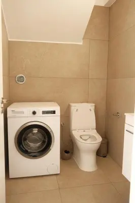 a bathroom with a washing machine and a toilet at Mediterranean Oasis Protaras in Protaras