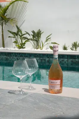 a bottle of wine and two wine glasses on a table at Mediterranean Oasis Protaras in Protaras