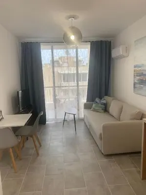 a living room with a couch and a table at Antonia Sea View Suite in Larnaka