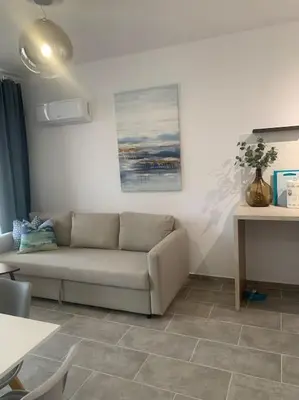 a living room with a couch and a table at Antonia Sea View Suite in Larnaka