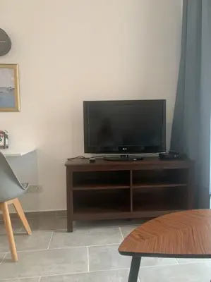 a flat screen tv sitting on top of a wooden entertainment center at Antonia Sea View Suite in Larnaka