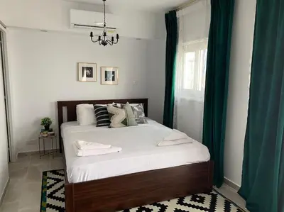 a bedroom with a large bed with blue curtains at Aria Sea View Studio in Larnaka