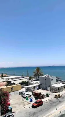 a parking lot with cars parked next to the ocean at Emma Sea View Suite in Larnaka