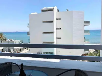 a balcony with a view of a building and the ocean at Emma Sea View Suite in Larnaka