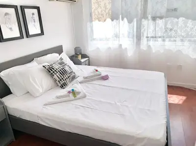 a bedroom with a white bed with towels on it at Emma Sea View Suite in Larnaka