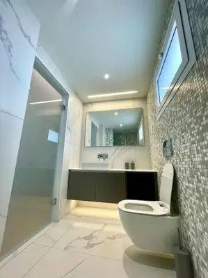 a bathroom with a toilet and a sink and a mirror at Penthouse Luxury Apartment in Nicosia