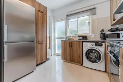 a kitchen with a refrigerator and a washing machine at Seaview Sanctuary House in Larnaka