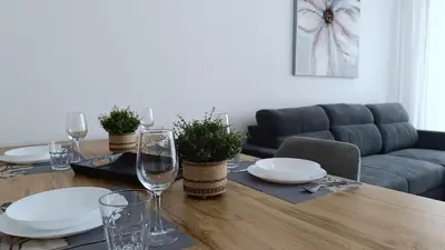 a dining room table with plates and wine glasses at Larvella Estia Luxury Suites in Larnaka