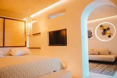 a bedroom with a bed and a couch in a room at Q Coconuts Seaside Suites in Limassol