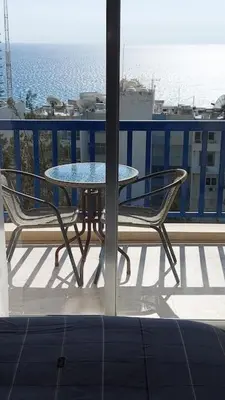 a table and chairs on a balcony with a view of the ocean at Peaceful Beach Location in Limassol