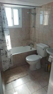 a bathroom with a toilet and a tub and a sink at Peaceful Beach Location in Limassol