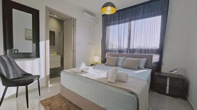 a bedroom with a bed with a chair and a window at STAY Digital Den Apartment in Larnaka