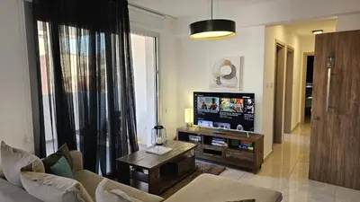 a living room with a tv and a couch and a table at STAY Digital Den Apartment in Larnaka