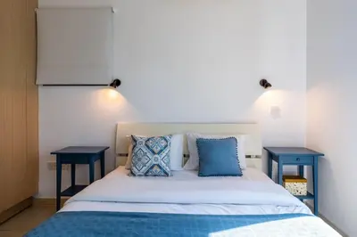 a bedroom with a bed with two blue tables at Lumina 2-Bedroom Villa and Pool in Ayia Napa in Ayia Napa