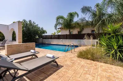 a backyard with a swimming pool and a house at Lumina 2-Bedroom Villa and Pool in Ayia Napa in Ayia Napa