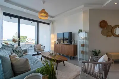 a living room with a blue couch and a table at Thálassa 2-Bedroom Apartment in Larnaca in Larnaka