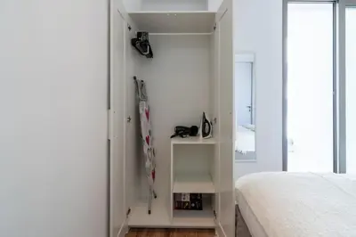 a white bedroom with a bed and a closet at Stars 1-Bedroom Apartment in Larnaca in Larnaka