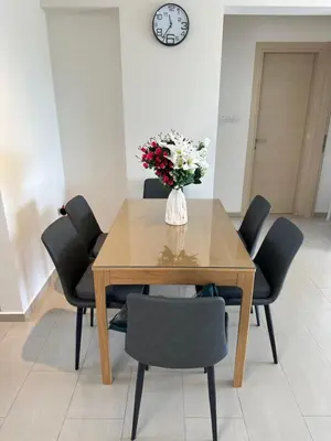 a dining room table with a vase of flowers on it at Kyklades Resort Excellence in Paralimni