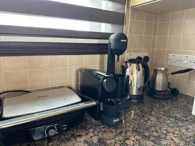 a kitchen counter with a coffee maker and a coffeemaker at Kyklades Resort Excellence in Paralimni