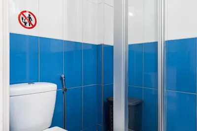 a blue and white bathroom with a toilet and a shower at Lazuli Stylish 1-BR Apt W Pool & Balcony in Larnaca in Voroklini