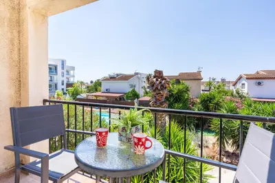 a balcony with a table and two cups on it at Lazuli Stylish 1-BR Apt W Pool & Balcony in Larnaca in Voroklini