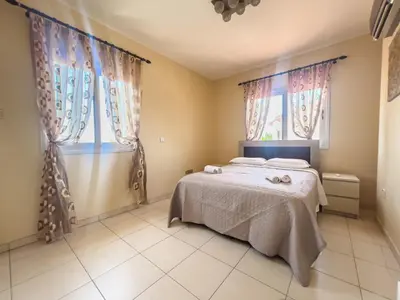 a bedroom with a bed and two windows at The Brilliant Villa in Protaras