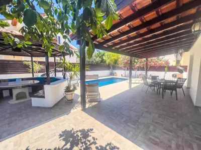 a patio with a table and chairs and a swimming pool at The Brilliant Villa in Protaras