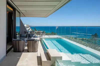a swimming pool with a view of the ocean at Amathus Residences in Limassol