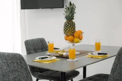 a dining room table with a pineapple and orange juice at Nissi Route 76 in Ayia Napa