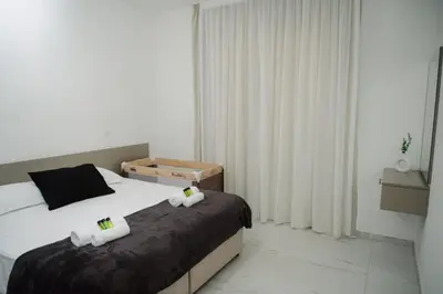 a bedroom with a bed with two towels on it at Nissi Route 76 in Ayia Napa