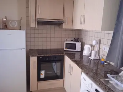 a kitchen with a white refrigerator and a microwave at Xylophagou Larnaca Ayia Napa Sunshine Apartments in Xylophaghou