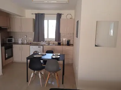a small kitchen with a table and chairs in it at Xylophagou Larnaca Ayia Napa Sunshine Apartments in Xylophaghou