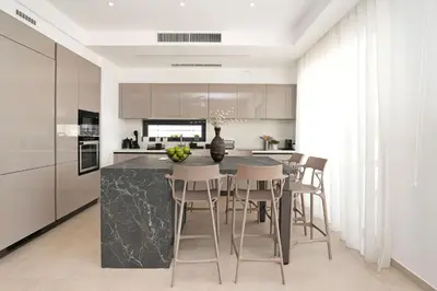 a kitchen with a black marble counter and stools at Levanda Platinum - Sunrise Sea View in Protaras