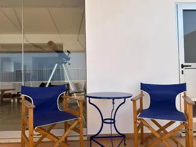 two blue chairs and a table in a room at Blue Penthouse Mackenzie in Larnaka