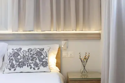 a bedroom with a bed and a window with a vase on a table at Attika Residence in Strovolos