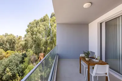 a balcony with a table and chairs and a large window at Attika Residence in Strovolos
